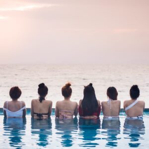 rear-view-woman-infinity-pool-against-sea-sunset